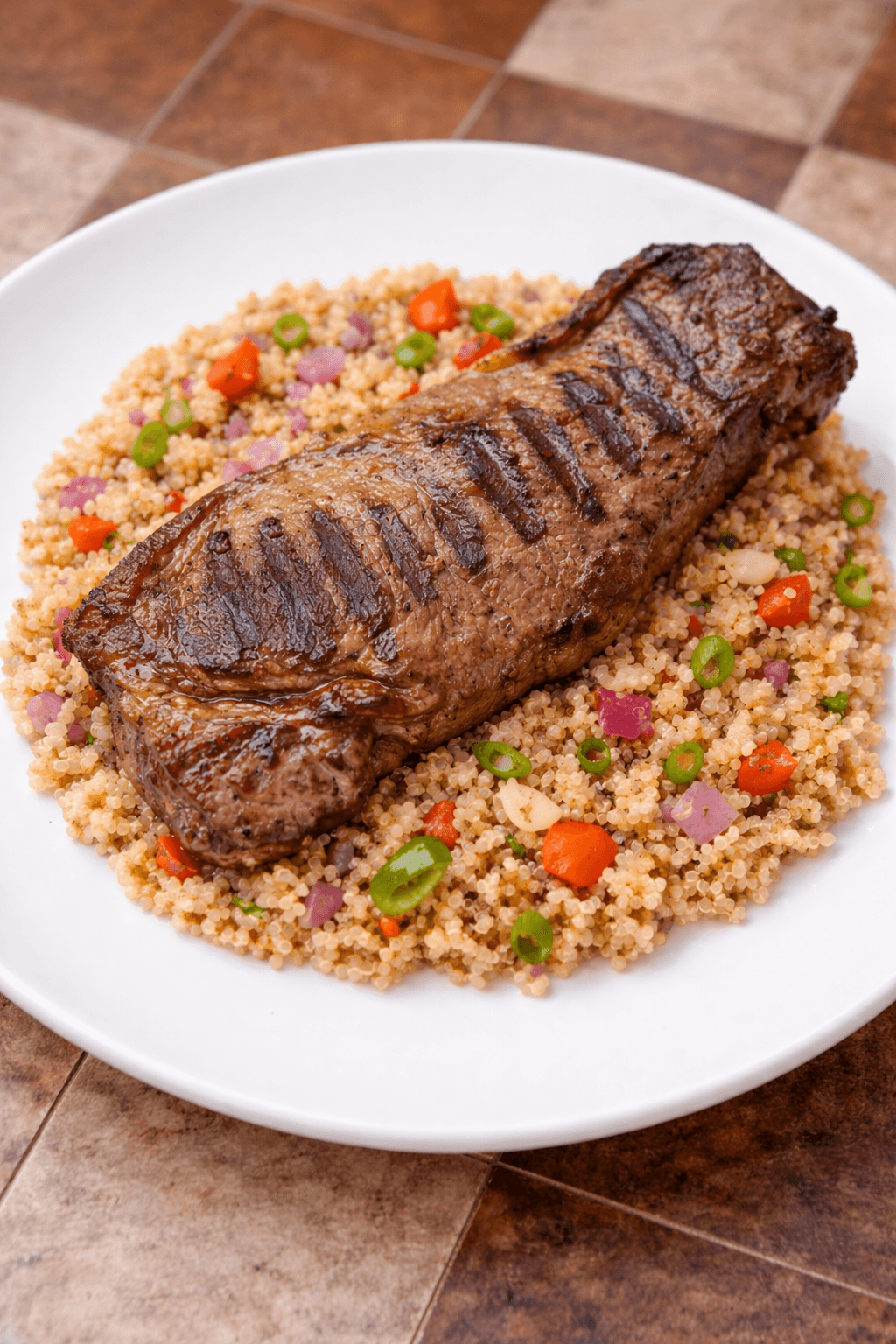 Bife de chorizo con revuelto de quinoa, zapallito, cebolla y morrón